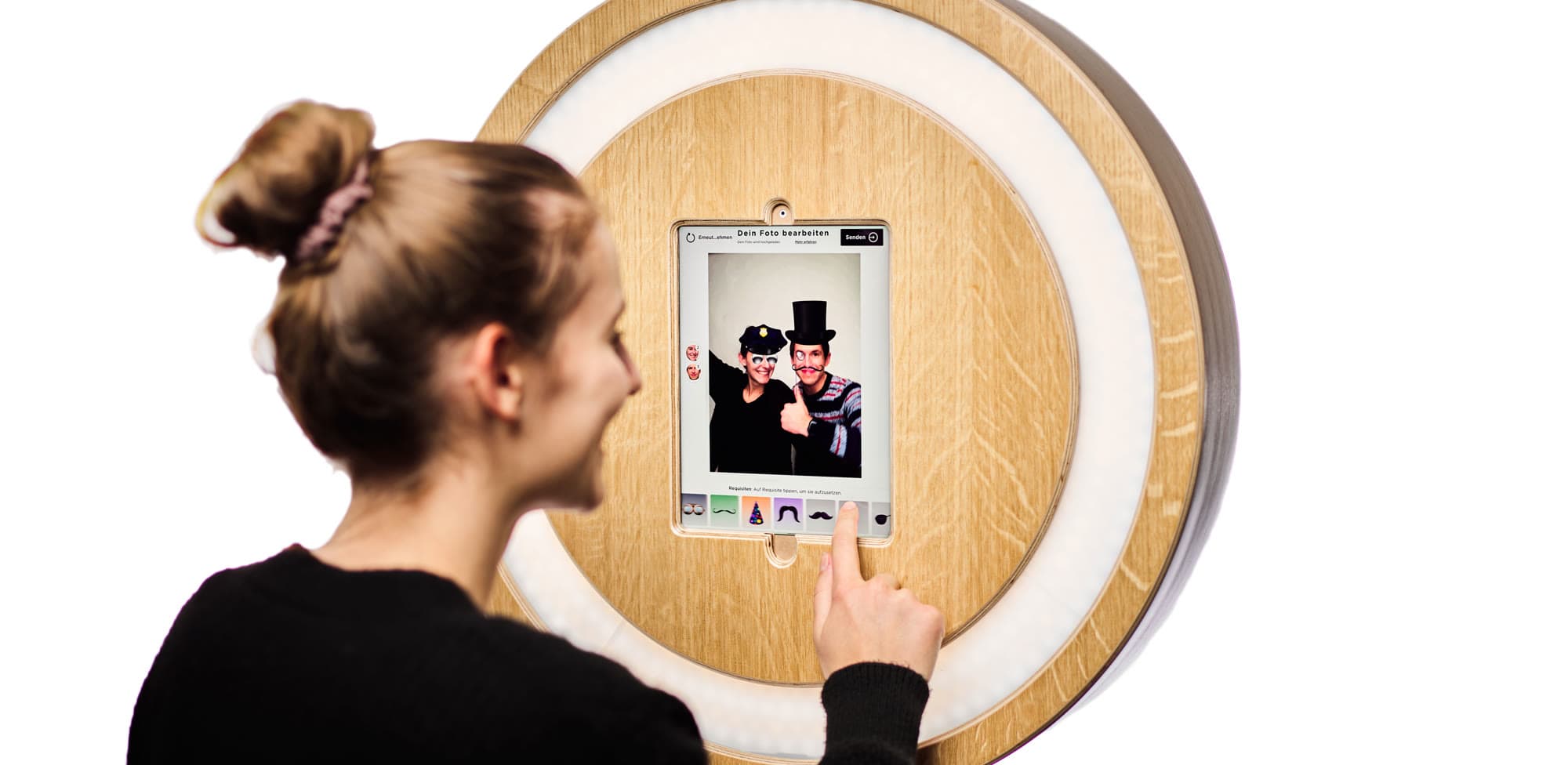 Eine Frau wählt am Tablet digitale Requisiten für ihr Foto